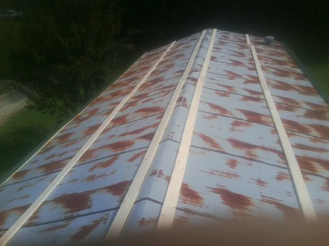 Rusted metal roof panels with new wood purlins before replacement — Storm Damage Roof Repair in La Belle by Roofing Brothers