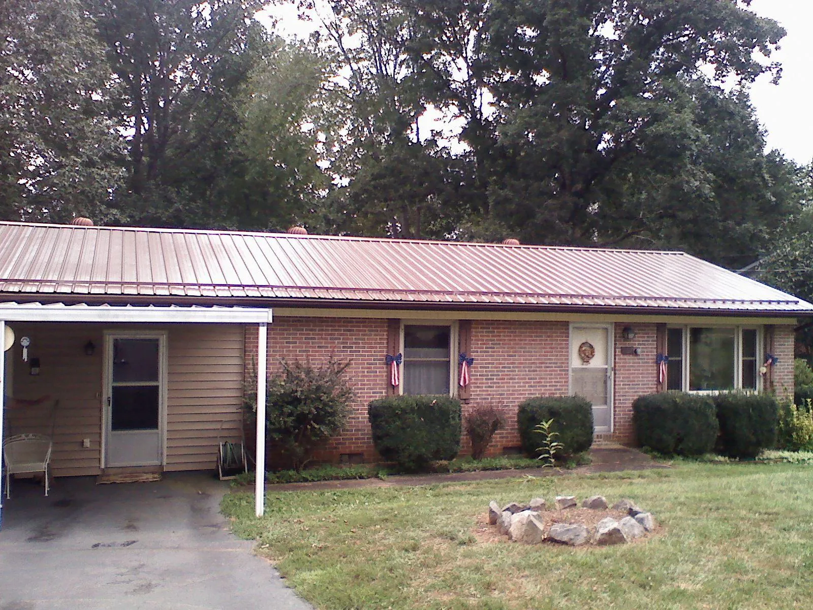 Bronze metal roof and carport on a brick ranch home — Roof Repair work by our crew in La Belle
